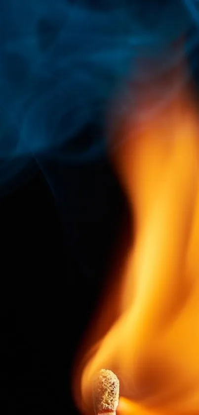 Orange match flame with blue smoke on dark background