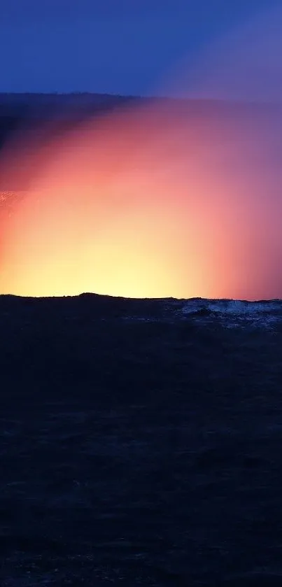 Lava crater glowing against a dark blue night sky, perfect for nature wallpaper.