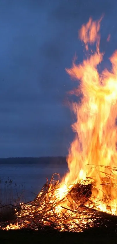 Vibrant fire burning by the beach at twilight.