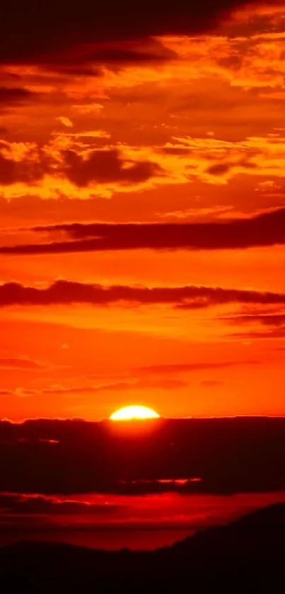 Fiery red sunset with dramatic clouds in the evening sky.