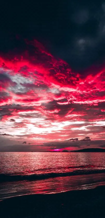 Dramatic sunset with red clouds over ocean horizon.