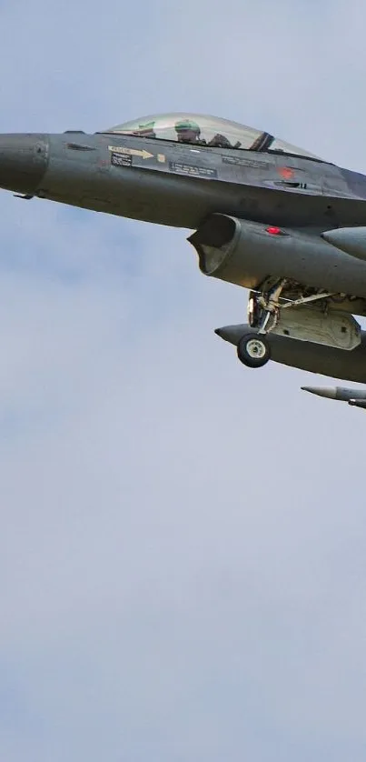 Fighter jet flying high in a clear blue sky, showcasing power and speed.