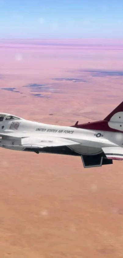 Fighter jet flying over a vast desert landscape.