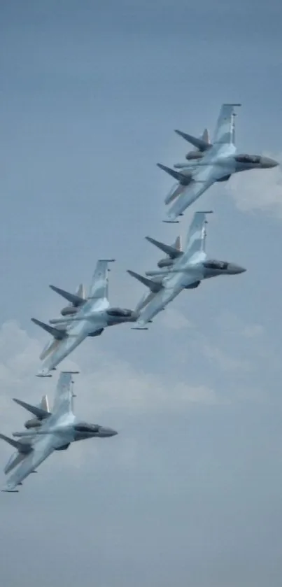 Four fighter jets flying in formation against a blue sky.