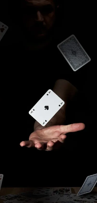 Floating playing cards in a dark setting with a hand.