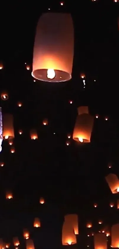 Glowing lanterns floating in night sky wallpaper.