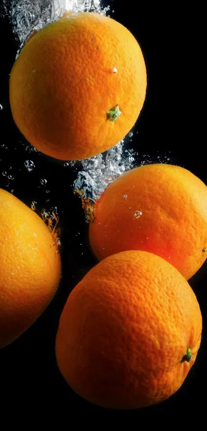 Oranges splashing in water against a black background.