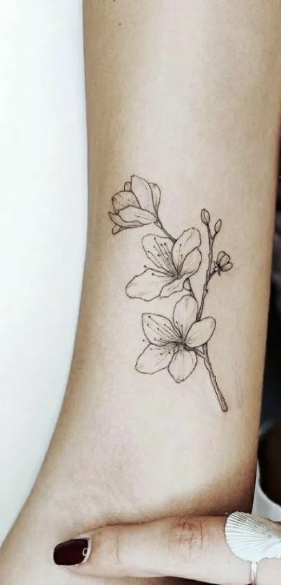 Floral tattoo design on arm in minimalistic style.