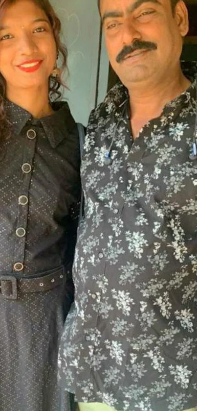 Stylish duo in black floral and buttoned outfits.