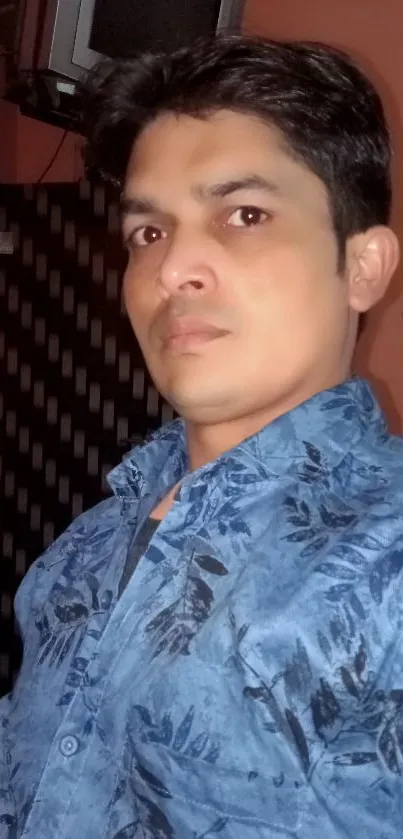 A person wearing a blue floral shirt, perfect for mobile wallpaper.