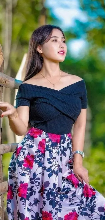 A serene outdoor portrait of a woman in a floral dress against a natural backdrop.