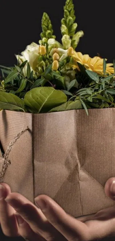 Hands holding a floral gift package with green leaves.