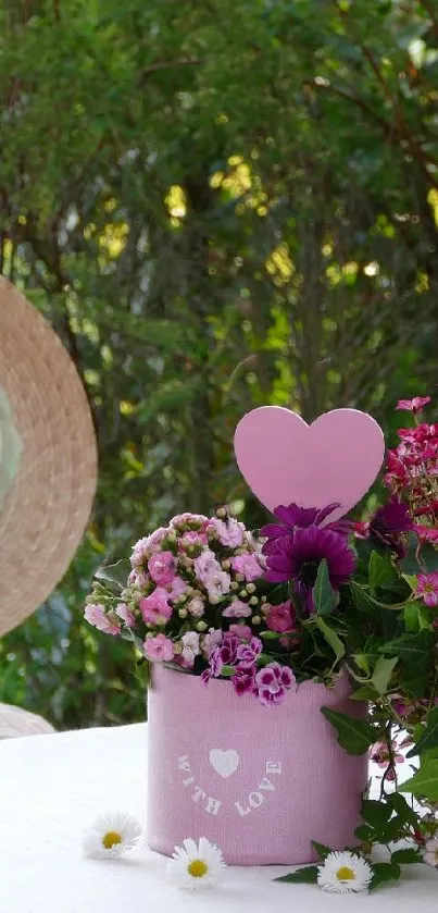 Straw hat and pink flowers on an outdoor table.