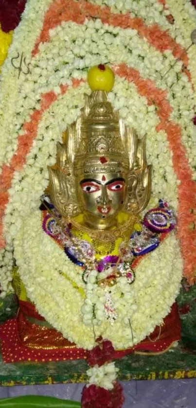 Hindu deity adorned with colorful flower garlands.