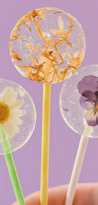 Three floral lollipops against a purple background.