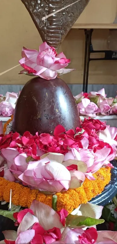 Mobile wallpaper featuring a Shiva Linga decorated with pink flowers.