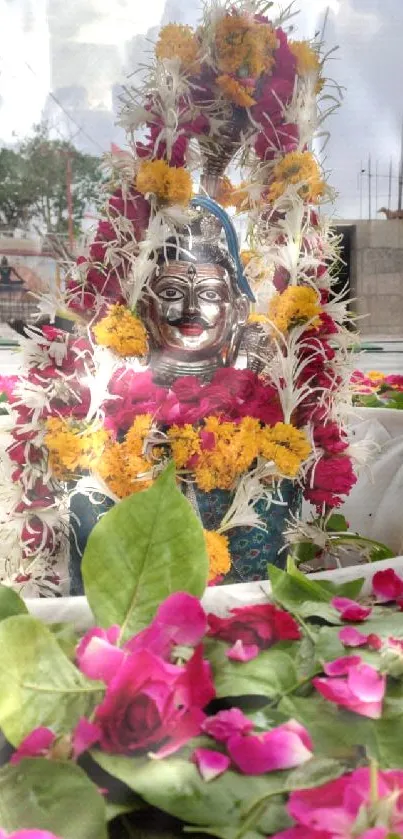 Statue adorned with flowers and leaves.