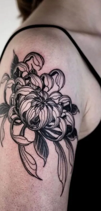 Intricate floral tattoo in black ink on arm.