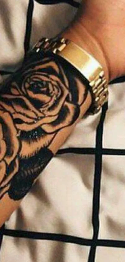 Arm with floral tattoo against patterned background.