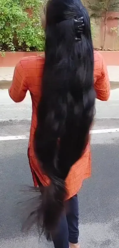 Woman with long black hair on street.