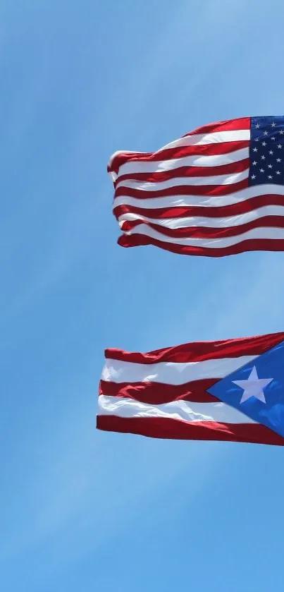 American and Puerto Rican flags waving under a bright blue sky.