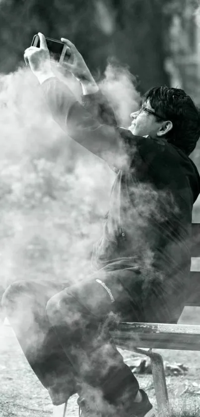 Man taking selfie surrounded by fog on a park bench.