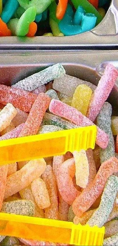 Vibrant gummy candy wallpaper with yellow tongs in a display.