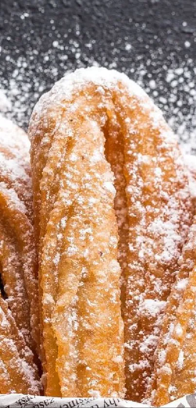 Golden churros dusted with powdered sugar.