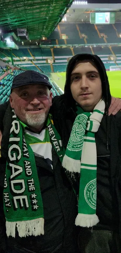 Two football fans with scarves at a vibrant stadium.