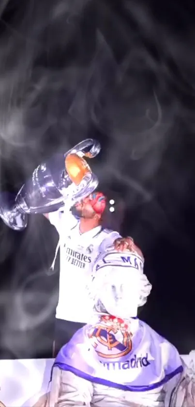 Football player lifting trophy in celebration with smoky background.