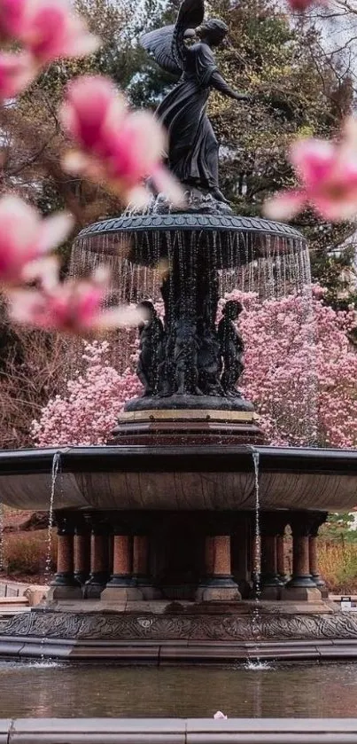 Fountain with flowing water surrounded by vibrant pink blossoms.