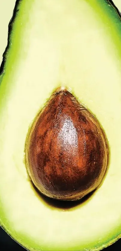 Vibrant green avocado wallpaper with seed on pale background.