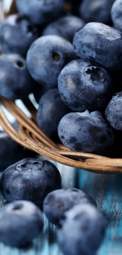 A close-up of fresh blueberries in a rustic basket on blue wood.