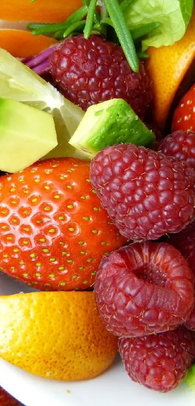 A bowl of colorful fruits and vegetables with strawberries and raspberries.