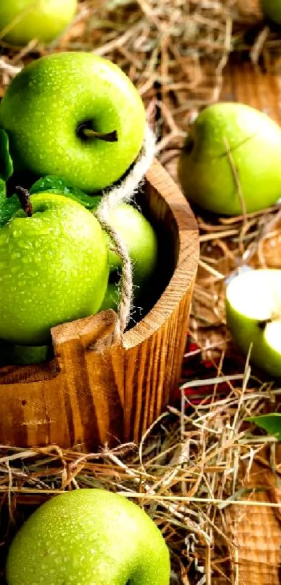 Green apples in a wooden basket with rustic hay on a wooden surface.