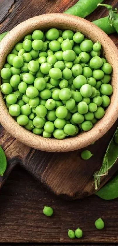 Bowl of fresh green peas on a rustic wooden board.