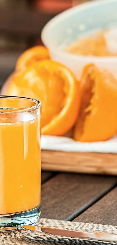Glass of fresh orange juice with sliced oranges on a wooden table.