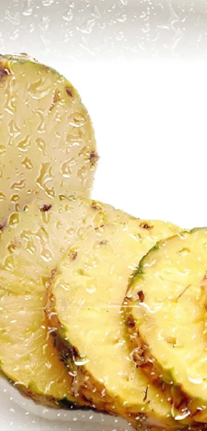Close-up of fresh pineapple slices with vibrant yellow color and water droplets.