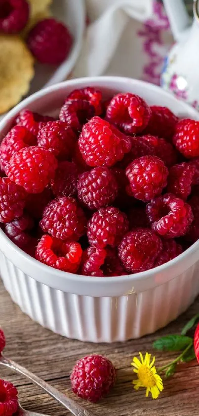 A white bowl filled with fresh, red raspberries on a wooden table.