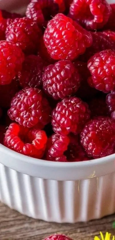 Fresh raspberries overflowing in a white ceramic bowl.