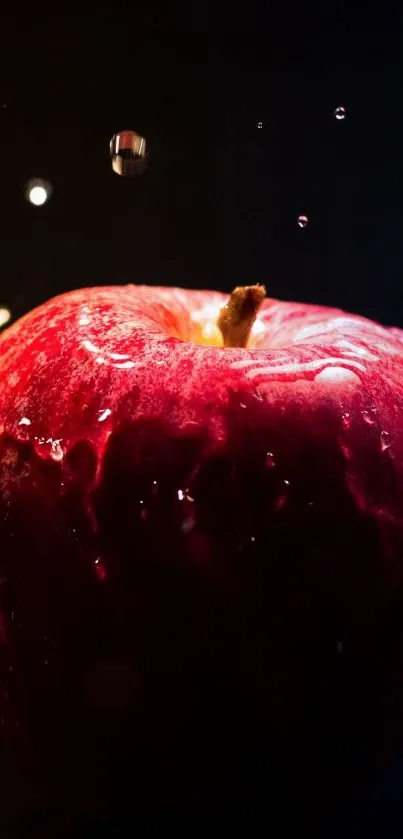 Vibrant red apple with water droplets on a dark background.