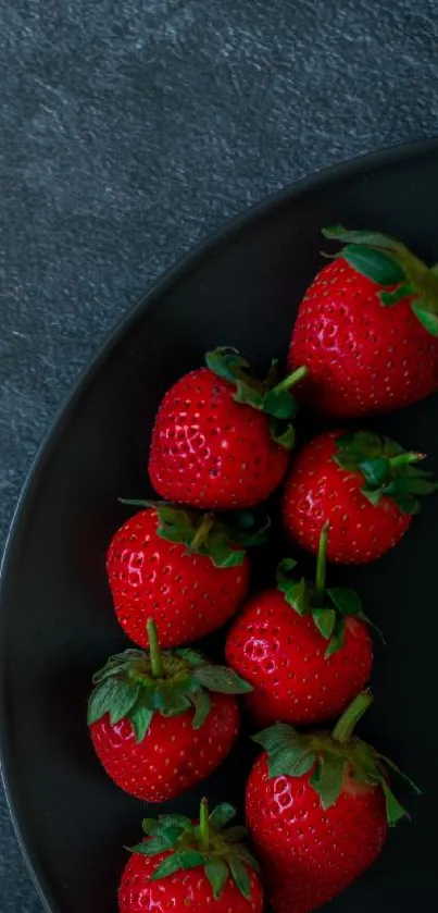 Fresh strawberries on a dark plate, vibrant mobile wallpaper.