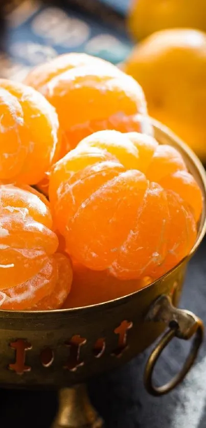 Golden bowl with peeled and whole tangerines on a dark background.