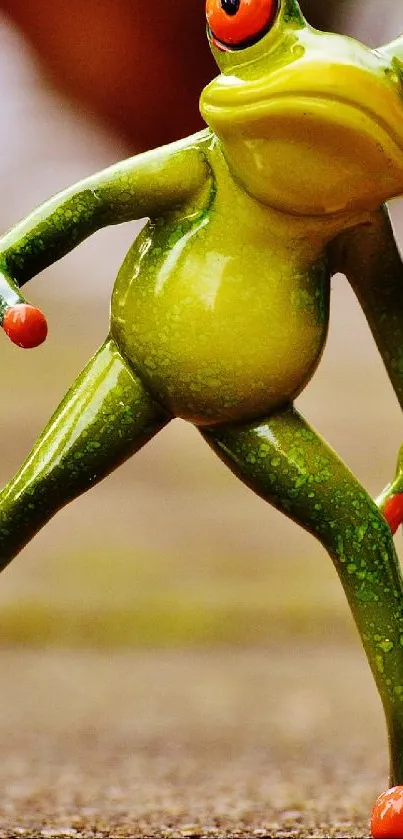 Green frog figurine playing soccer with a ball on a natural background.