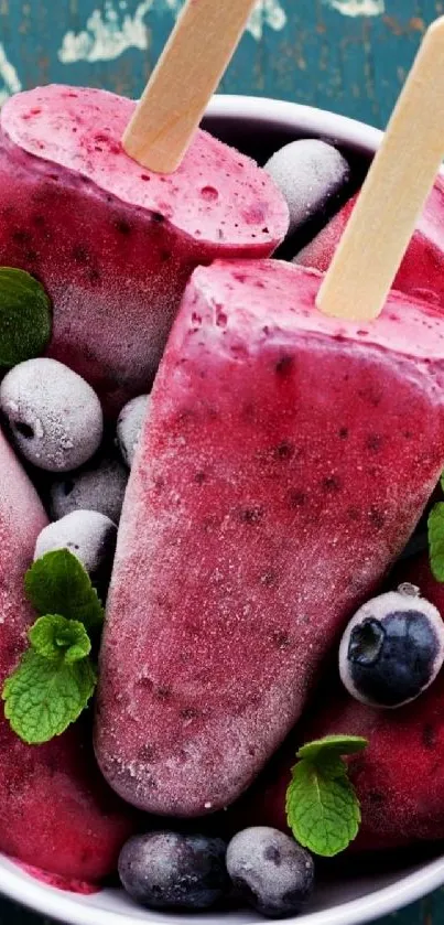 Frozen berry popsicles with blueberries in a bowl.