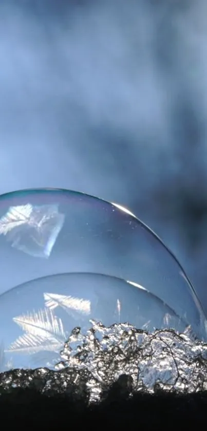 Close-up of a frozen bubble on ice with a blue sky in the background.