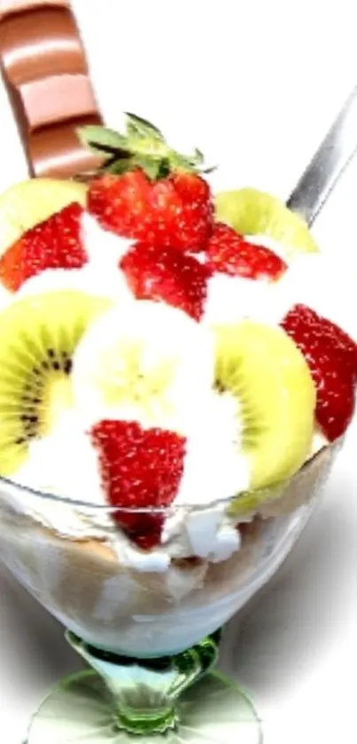 Glass of fruit dessert with strawberries, kiwi, and chocolate.