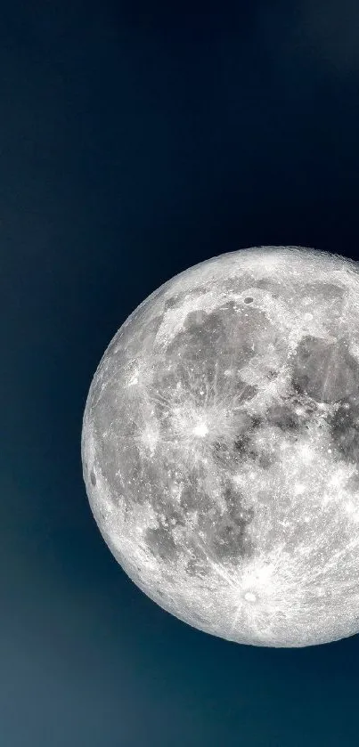 Full moon against a dark blue sky with subtle clouds.