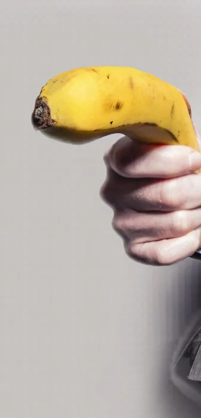 Hand holding a banana in a quirky wallpaper design.