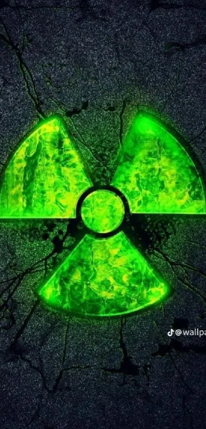 Neon green radiation symbol on cracked dark surface.